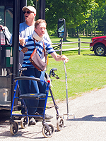 Photo of a man with a walker exiting a handicap accessible bus.