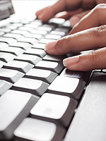 Photo of fingers typing on a computer keyboard.